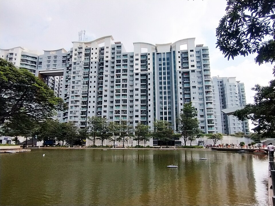 Completed residential apartment towers beside landscaped water in Bengaluru